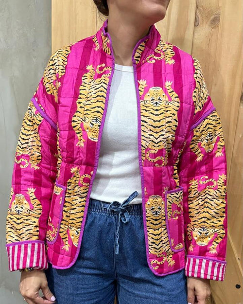 Person wearing a bright pink jacket with yellow tiger patterns, white shirt, and blue jeans.
