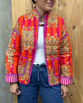 Woman wearing a colorful jacket with a wooden background